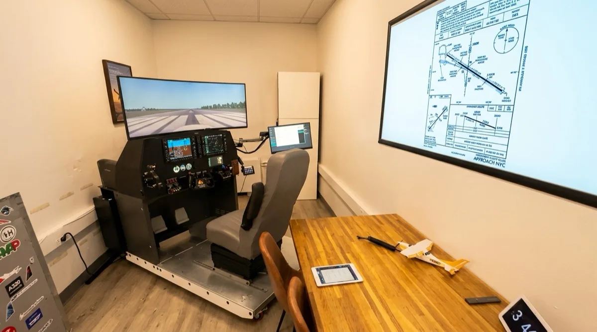 Aviator.NYC simulator briefing room with IFR approach plate displayed on projector — pre-flight briefing setup in Hudson Square, Manhattan