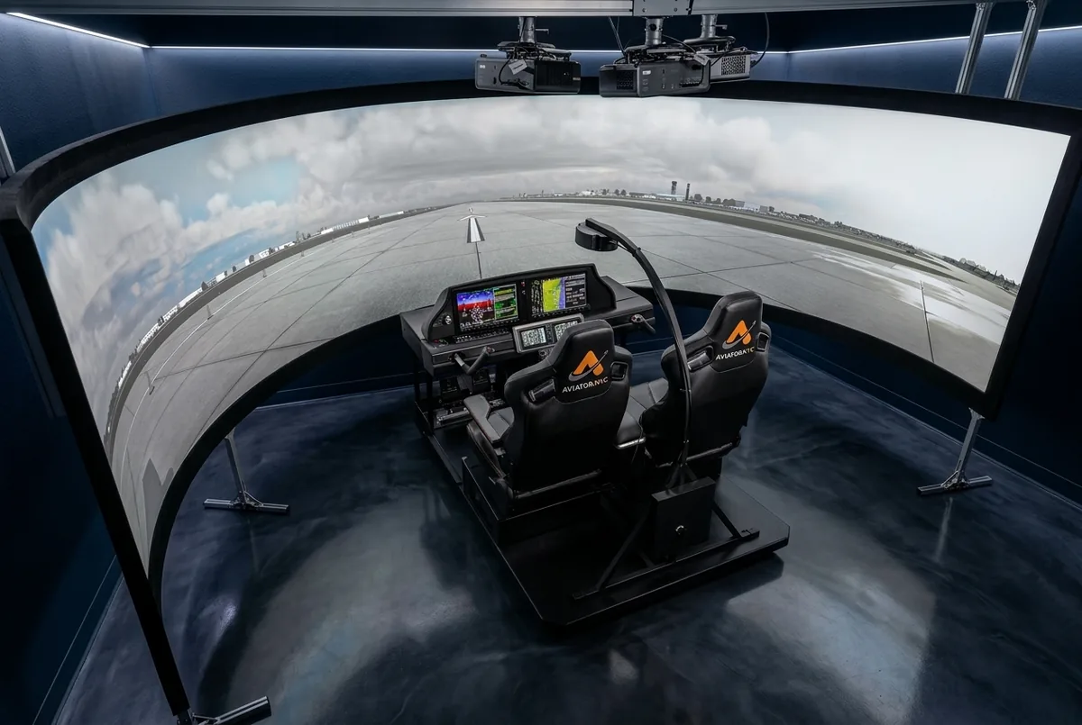 Cirrus G3000 flight simulator with Garmin Perspective Touch avionics and 220-degree wraparound projection display at Aviator.NYC training facility in Midtown Manhattan