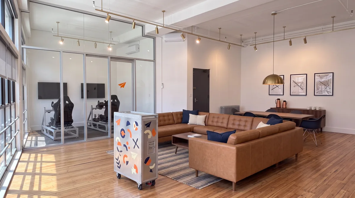 AI-generated rendering of the planned Midtown studio lounge with the sticker-covered airline galley cart and framed aviation prints