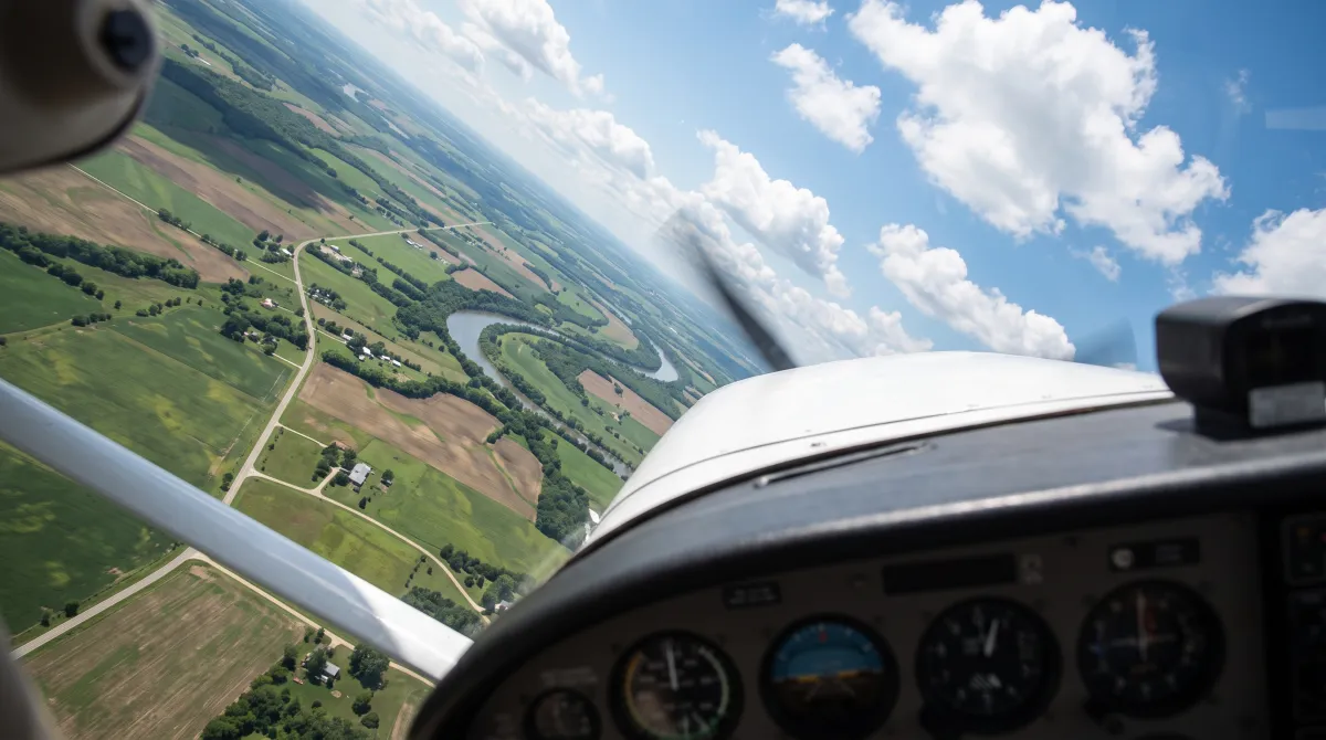 AI-generated preview of maneuver practice: view over the nose of a GA airplane holding a steep turn over farmland